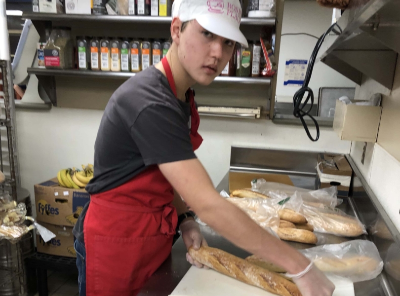Youth cutting bread at Rosie's Place