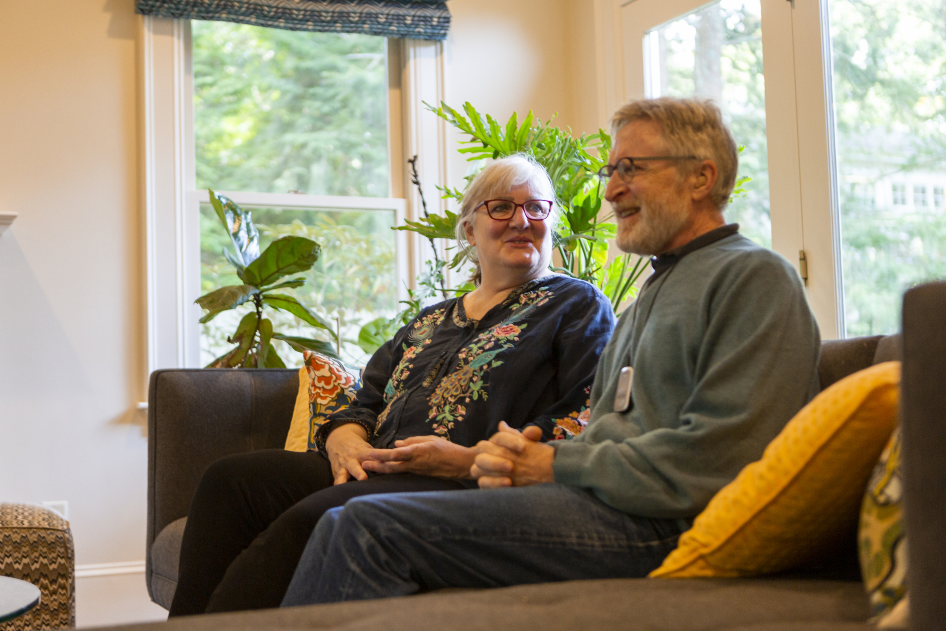 A man and woman talk while sitting in their living room